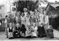 <p>Nauczyciele: Irena Ślązak oraz Stefan Kubacki z grupą dzieci na placu przed gimnazjum w Łapach. Ok. 1955 rok. Fot. NN. Z albumu TPD w Łapach</p>
